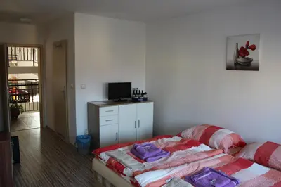 a living room with a bed and a television at Penzion Piller in Chvalín