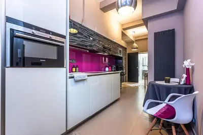 a kitchen with purple walls and a table with a chair at Apartment Municipal house Prague 1 Old town in Prague