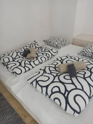 two beds with black and white sheets and pillows at Unique apartment near Charles Bridge in Prague
