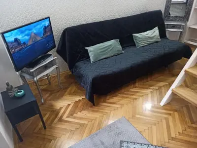 a black couch in a living room with a flat screen tv at Unique apartment near Charles Bridge in Prague