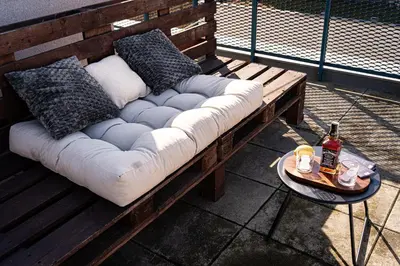 a couch with pillows and a table with a bottle of beer at Penthouse Tiger Deluxe in Prague