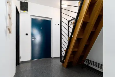 a hallway with a blue door and stairs at Penthouse Tiger Deluxe in Prague