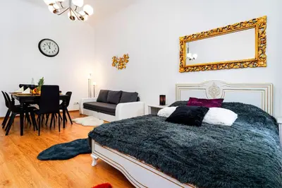 a bedroom with a bed and a table and a mirror at Black Diamond Suite in Prague