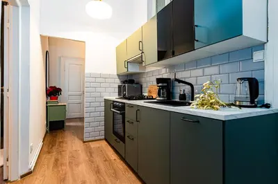 a kitchen with black cabinets and blue tiles at Black Diamond Suite in Prague