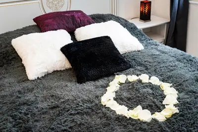 a bed with black and white pillows and a bowl on it at Black Diamond Suite in Prague