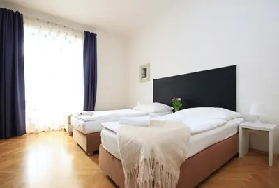 a bedroom with two beds and a large window at Quadrio Bedroom Central Apartment in Prague
