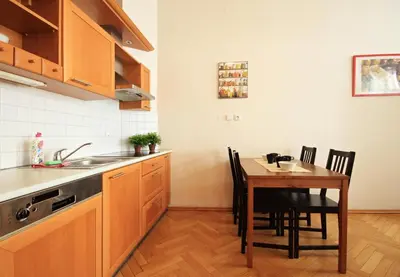 a kitchen with a wooden table and a table and chairs at Quadrio Bedroom Central Apartment in Prague
