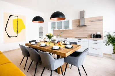 a dining room with a wooden table and chairs at Centrum Apartments Pstrossova in Prague