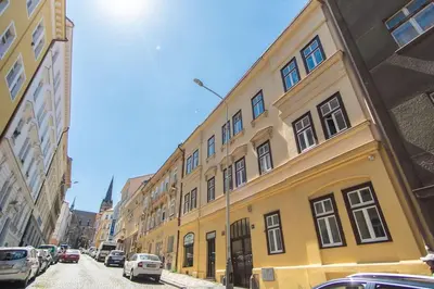 a yellow building on the side of a street at Nice one bedroom apartment in zizkov in Prague