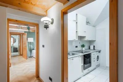 a kitchen with white cabinets and a door leading to a hallway at Delux Romantic Stay Prague in Prague