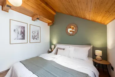 a bedroom with a white bed with a wooden ceiling at Delux Romantic Stay Prague in Prague