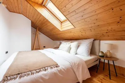 a bedroom with a large white bed with a skylight at Delux Romantic Stay Prague in Prague