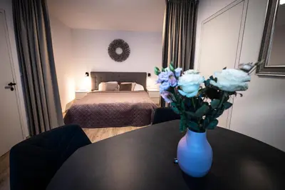 a room with a table with a vase with flowers on it at Luxury Angel Apartment with terrace in Prague