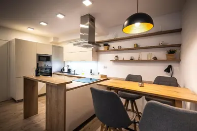 a kitchen with a wooden table and chairs at Luxury Angel Apartment with terrace in Prague