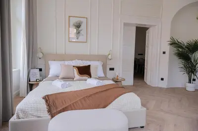 a white bedroom with a large bed with two pillows at Rentero apartment, 4 minutes National Theather, Prague in Prague