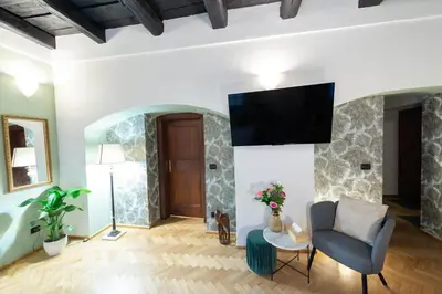 a living room with a chair and a tv on a wall at Adam's Apartment - Great Price & Best Location in Prague