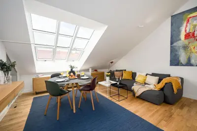 a living room with a table and a couch at Prague Days - One bedroom newly renovated apartment with workspace and Netflix in Prague