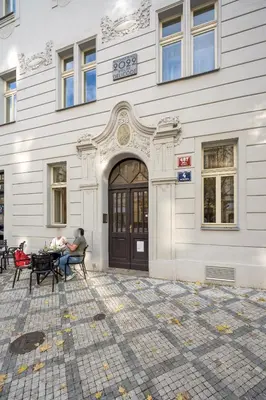 a building with people sitting at a table in front of it at Prague Days - One bedroom newly renovated apartment with workspace and Netflix in Prague