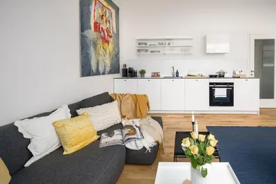 a living room with a couch and a kitchen at Prague Days - One bedroom newly renovated apartment with workspace and Netflix in Prague