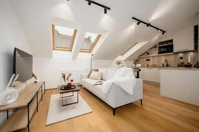 a living room with a white couch and a kitchen at Prague Days - Two-bedroom Apartment with Workspace and Netflix in Nusle in Prague