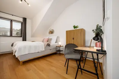 a bedroom with a bed and a desk and a table at Prague Days - Two-bedroom Apartment with Workspace and Netflix in Nusle in Prague