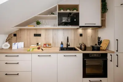 a kitchen with white cabinets and a black stove at Prague Days - Two-bedroom Apartment with Workspace and Netflix in Nusle in Prague