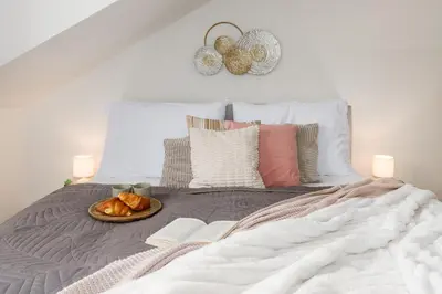 a bed with a plate of bread on it at Prague Days - Two-bedroom Apartment with Workspace and Netflix in Nusle in Prague