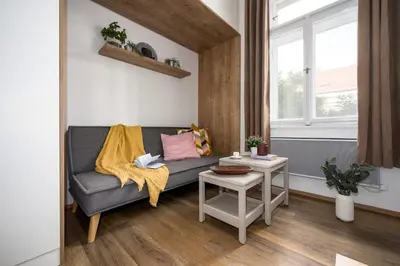 a living room with a couch and a table at Prague Days - Cozy Studio with Netflix in Karlín in Prague