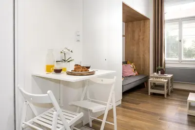 a small kitchen and living room with a table and chairs at Prague Days - Cozy Studio with Netflix in Karlín in Prague