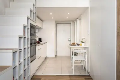 a kitchen with white cabinets and a small island at Prague Days - Cozy Studio with Netflix in Karlín in Prague