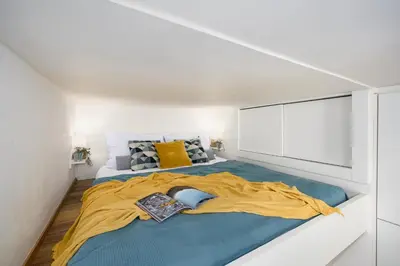 a bedroom with a large bed with a yellow blanket at Prague Days - Cozy Studio with Netflix in Karlín in Prague