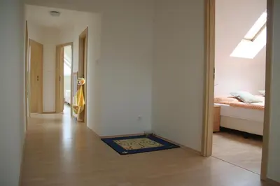 a hallway with a bedroom and a bed and a rug at Holiday Home Prague Pruhonice in Pruhonice