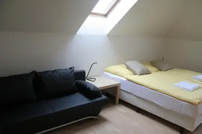 a room with a bed and a couch and a window at Holiday Home Prague Pruhonice in Pruhonice