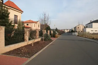 an empty street in a residential neighborhood with houses at Holiday Home Prague Pruhonice in Pruhonice