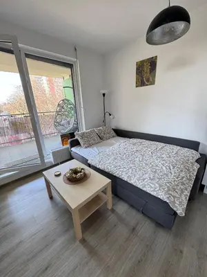 a bedroom with a bed and a table and a window at Terrace Apartman Víšek in Prague