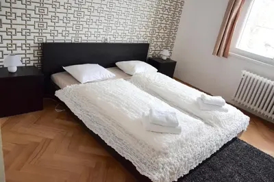 a bedroom with two beds with white sheets and a window at Classical House in Prague 6 in Prague