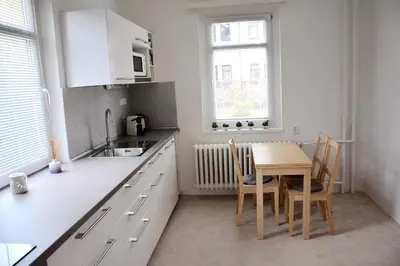 a kitchen with a table and chairs and a sink at Classical House in Prague 6 in Prague