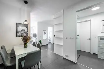 a white dining room with a table and chairs at All-in Family Apartment Prague in Prague