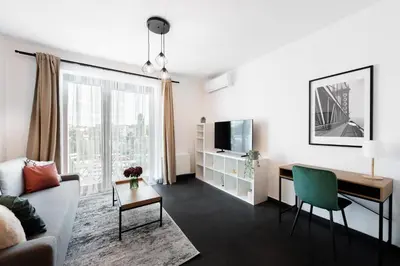 a living room with a couch and a desk at All-in Family Apartment Prague in Prague