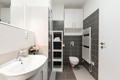a white bathroom with a sink and a toilet at All-in Family Apartment Prague in Prague