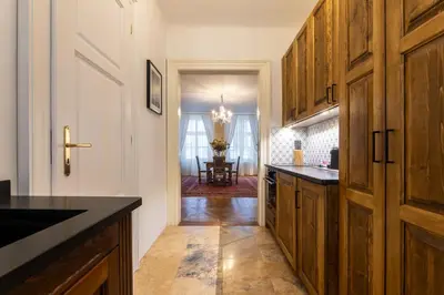 a kitchen with wooden cabinets and a black counter top at King's Royal Apartments in City Centre in Prague
