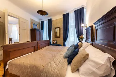 a bedroom with a large bed with blue curtains at King's Royal Apartments in City Centre in Prague