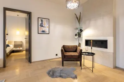a living room with a chair and a television at Chic & Central New Town Apartment by Subway in Prague