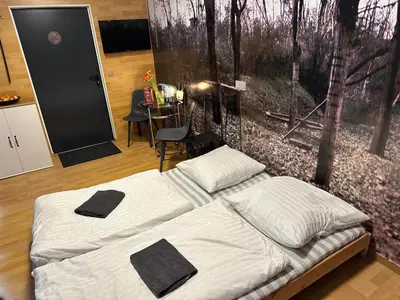 a bedroom with a bed with two black towels on it at Tenis Cibulka Suites in Prague