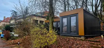 a black and orange house on the side of a street at Tenis Cibulka Suites in Prague