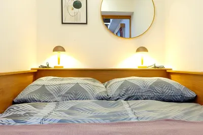 a bed with two pillows and a mirror on the wall at The Wenceslas Loft in Prague