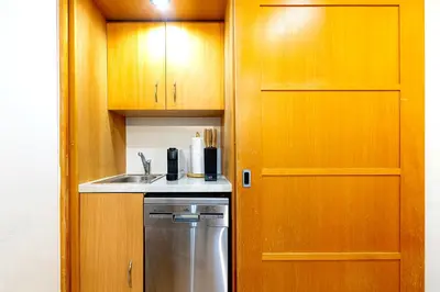 a kitchen with wooden cabinets and a stainless steel dishwasher at The Wenceslas Loft in Prague