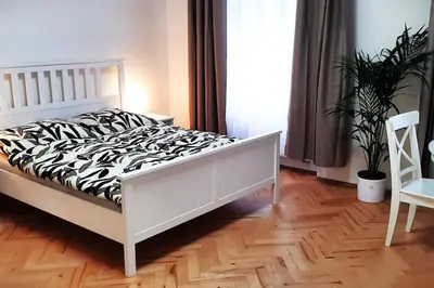 a bedroom with a white bed with a zebra print sheets at Arbes apartman in Prague