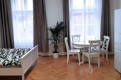 a room with a table and chairs and a bedroom at Arbes apartman in Prague