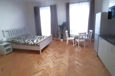a bedroom with a bed and a table and chairs at Arbes apartman in Prague
